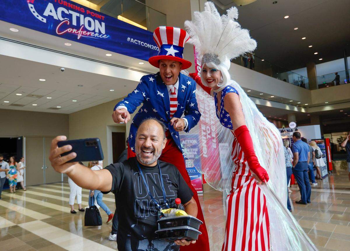 Nick Gall and Kelly Slaton with Palm Beach Stilts pose with Oscar Chacon during the Turning Point Action Conference at the Palm Beach County Convention Center in West Palm Beach, Florida, on Saturday, July 15, 2023.