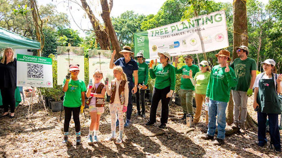 Girls scouts lead volunteers in reciting the Girl Scout Promise at an October tree planting.