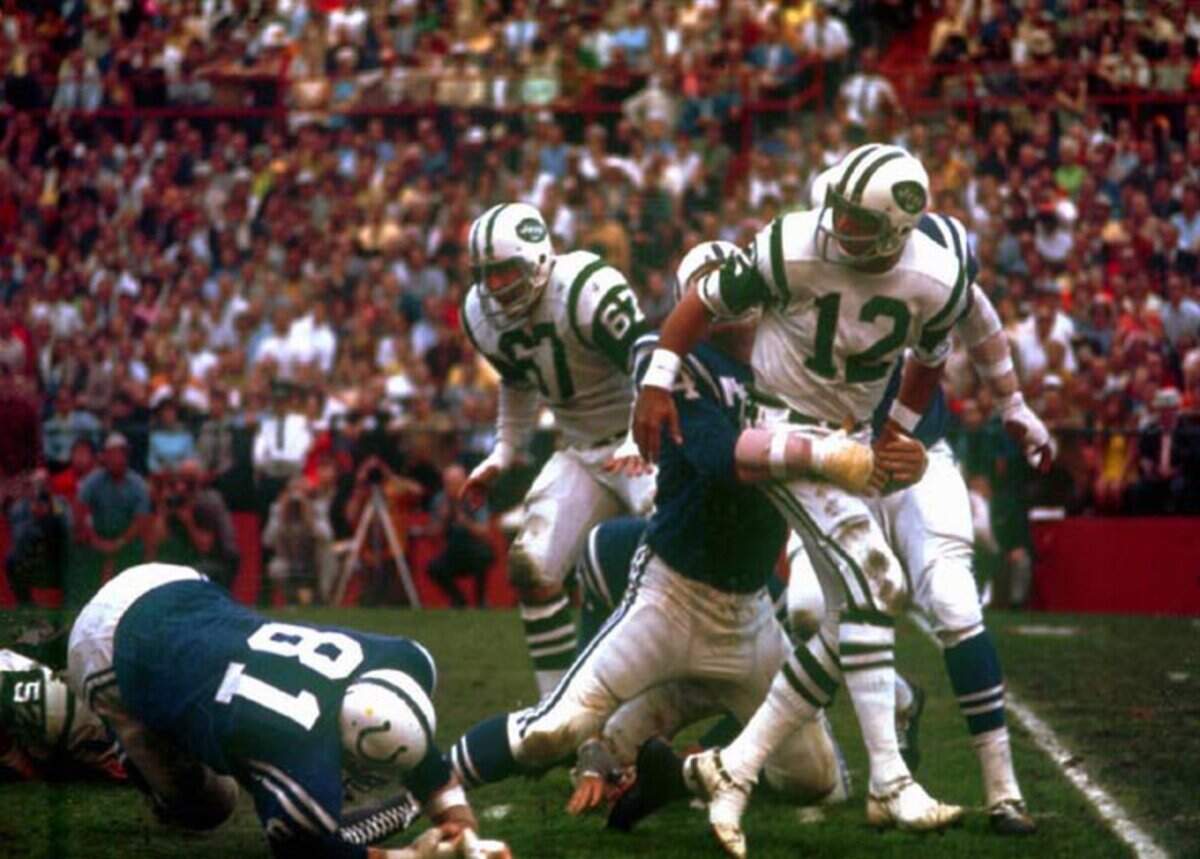 New York Jets quarterback Joe Namath (12) gets a pass away against the Baltimore Colts under pressure from a Colts defender, in Super Bowl III, Jan. 12, 1969, in Miami. The Jets won, 16-7.