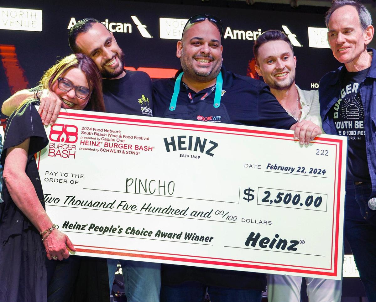 Rachel Ray gets a hug from Pincho Factory founder Otto Othman, who’s next to Chef Adrian Sanchez at 2024 Burger Bash. Pincho’s jalapeño burger was the People’s Choice Award winner.