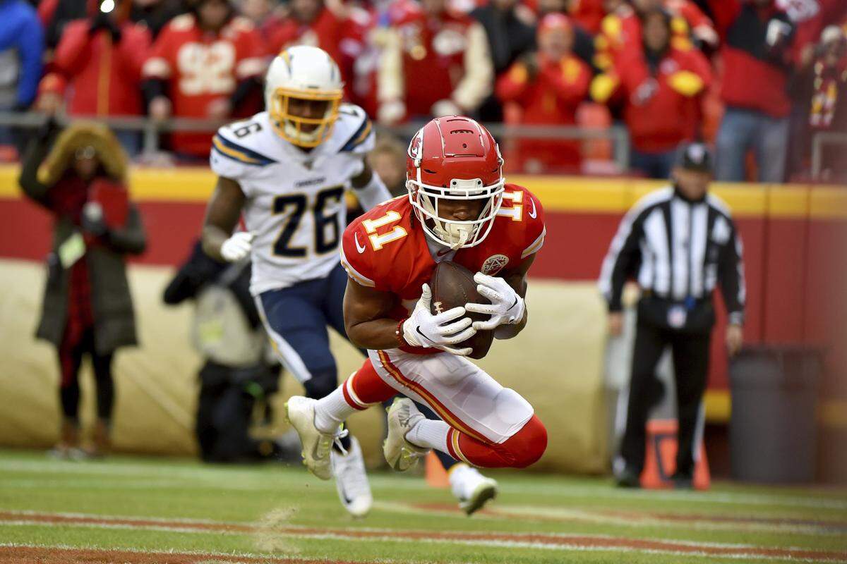 Kansas City Chiefs wide receiver Demarcus Robinson (11) scores a touchdown in front of Los Angeles Chargers cornerback Casey Hayward Jr. (26) during the first half of an NFL football game in Kansas City, Mo., Sunday, Dec. 29, 2019.