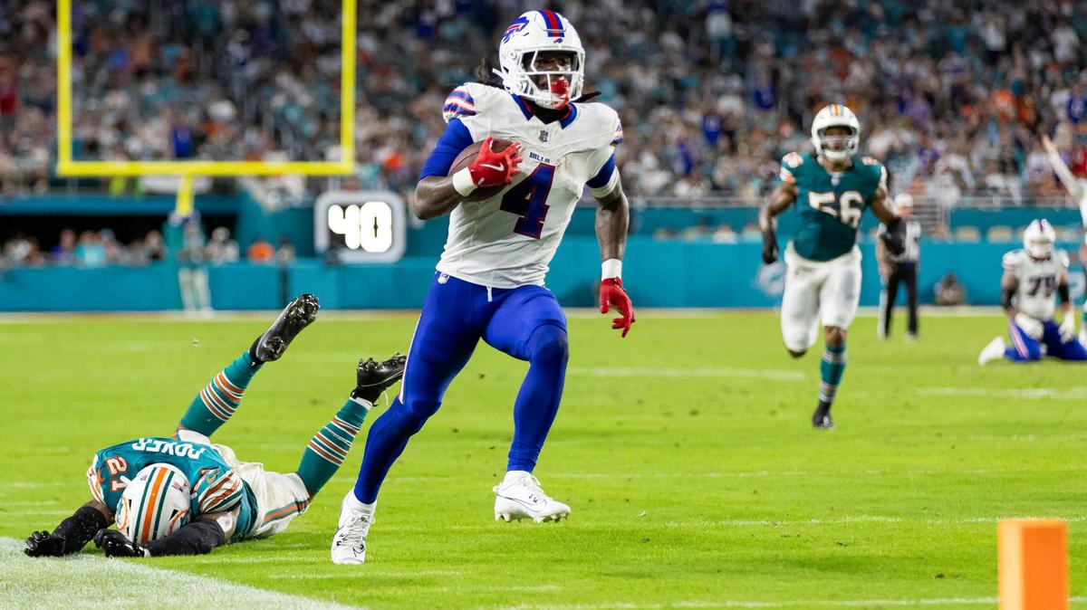 Buffalo Bills running back James Cook (4) slips past Miami Dolphins safety Jordan Poyer (21) in the first half of their NFL game at Hard Rock Stadium on Thursday, Sept. 12, 2024, in Miami Gardens, Fla.