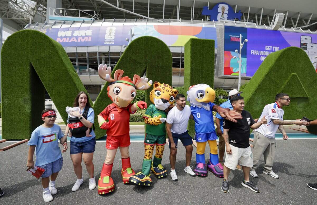 Soccer fans stand with mascots outside Miami Stadium before the start of Uruguay against Saudi Arabia FIFA World Cup opening match on Monday, June 15, 2026.