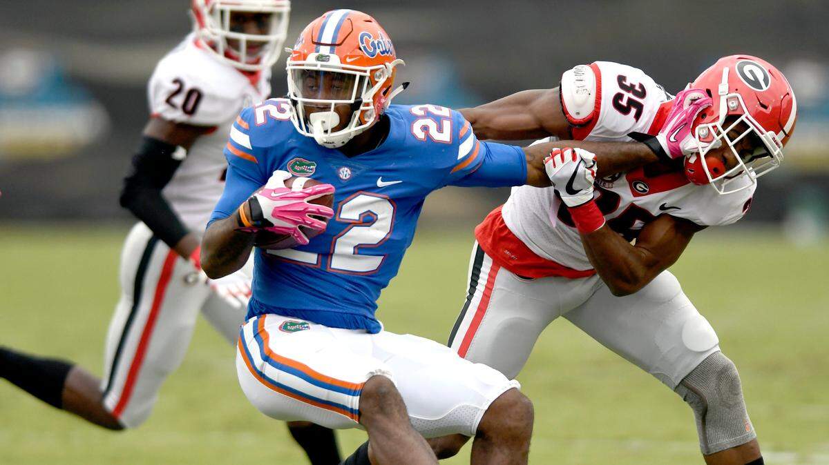 Florida running back Lamical Perine (22) is stopped at the line of scrimmage Georgia defensive back Aaron Davis (35) during their game Saturday in Jacksonville.