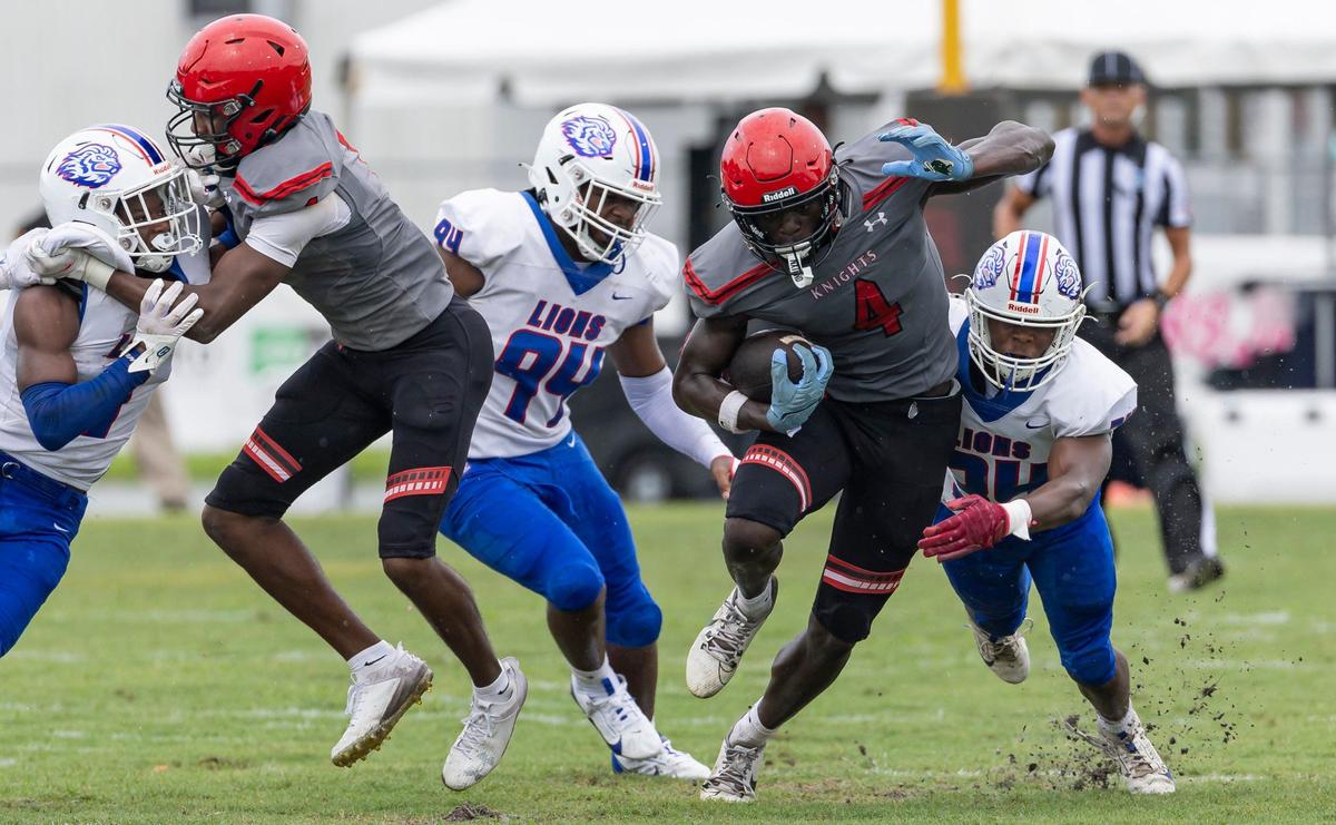 Monarch Knights wide receiver Antwaun Parham (4) runs with the ball as Peachtree Ridge Lions linebacker Seyon Bedell (34) and defensive lineman Ryan Gaudin (94) try to tackle him in the first half of their football game at Coconut Creek High School on Thursday, Aug. 22, 2024, in Coconut Creek, Fla.