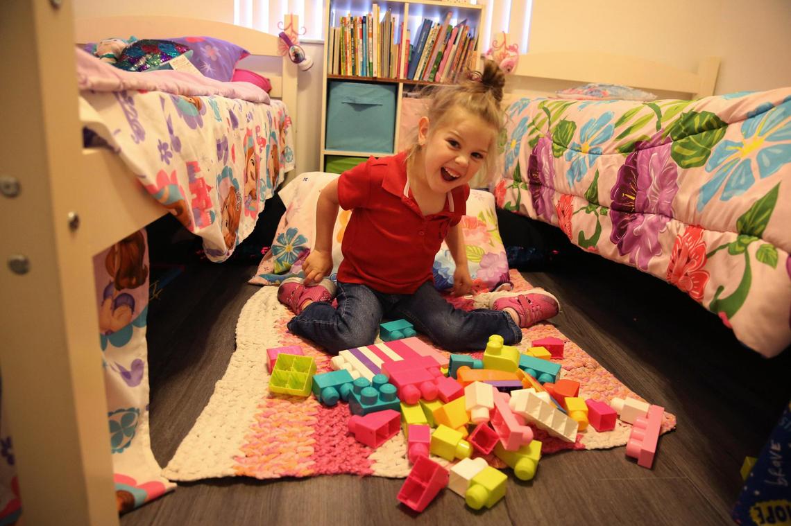 Brooklyn plays with blocks in the bedroom she shares with her sister.