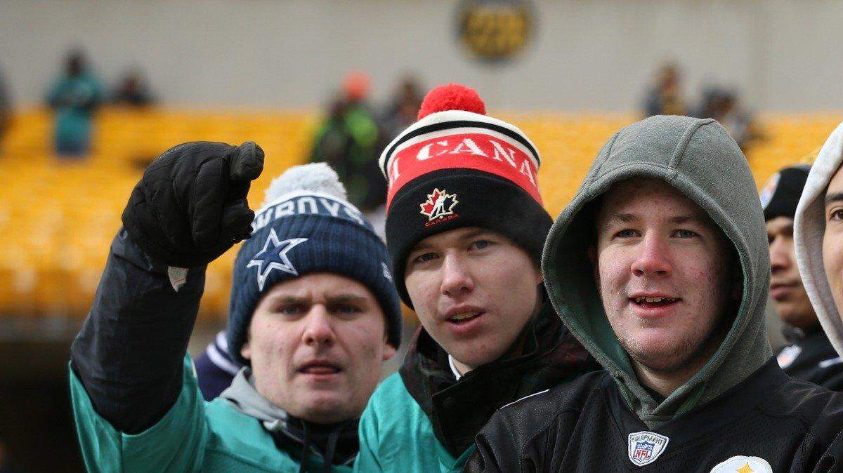 Frozen Dolphins and Steelers fans whoop it up before Sunday's playoff game in Pittsburgh.
