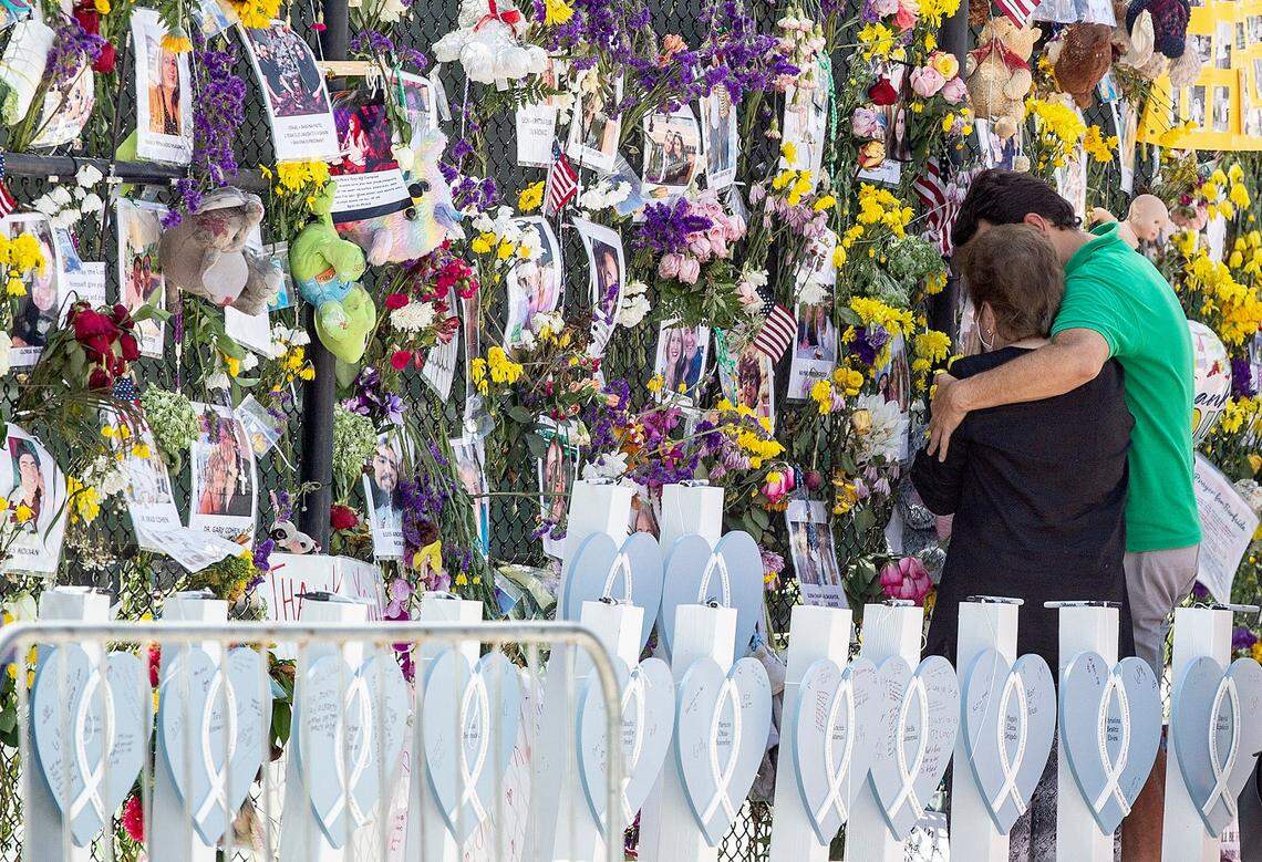 People mourn at the memorial wall for the victims of the Champlain Towers South collapse in Surfside on Thursday, July 8, 2021.