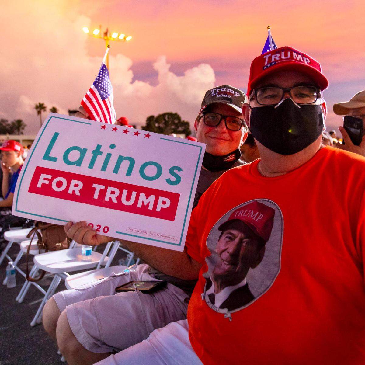 Trump supporters and Miami residents Juan Llanes, 57, and George Hubbard, 53, sit as they wait for Donald Trump Jr. to speak at the ‘Fighters against Socialism’ event at the Wings Over Miami Museum in Miami, Florida, on Sunday, October 11, 2020.