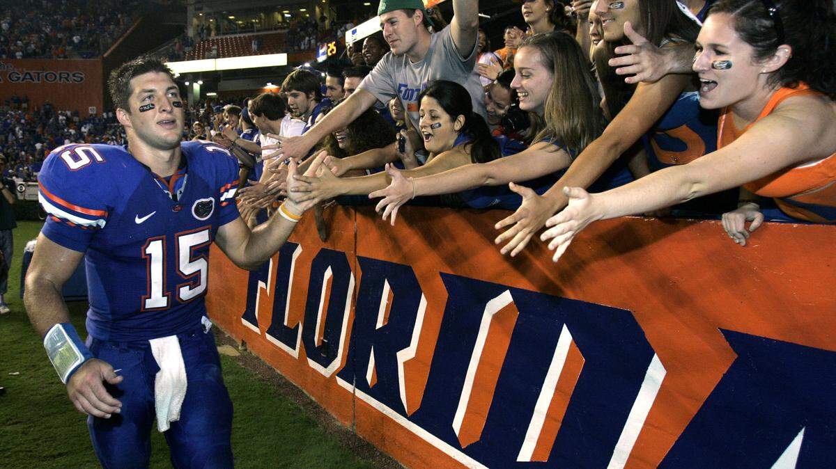 In 2008, then Florida Gators quarterback Tim Tebow (15) high-fives fans after defeating LSU in an NCAA college football game in Gainesville. No. 22 Florida is honoring their most famous quarterback again. The Gators will induct Tebow into the program’s Ring of Honor at halftime of Saturday’s game against fifth-ranked LSU.