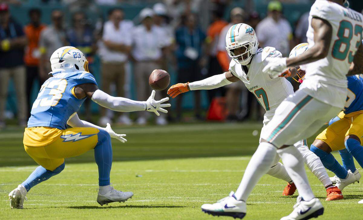 Los Angeles Chargers safety Tony Jefferson (23) catches an interception as Miami Dolphins wide receiver Jaylen Waddle (17) looks on in the first half of their NFL game at Hard Rock Stadium on Sunday, Oct. 12, 2025, in Miami Gardens, Fla.