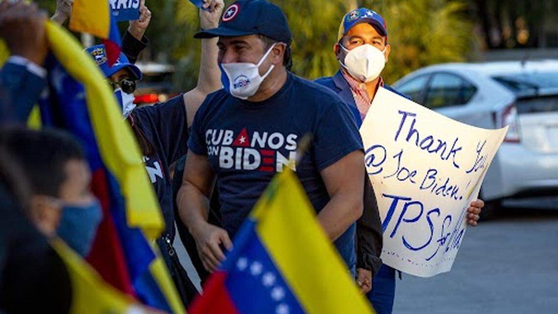 People wave the flag of Venezuela and signs thanking President Joe Biden as they celebrate the approval of Temporary Protected Status for more than 300,000 Venezuelan citizens living in the United States, at El Arepazo restaurant in Doral on March 9, 2021.