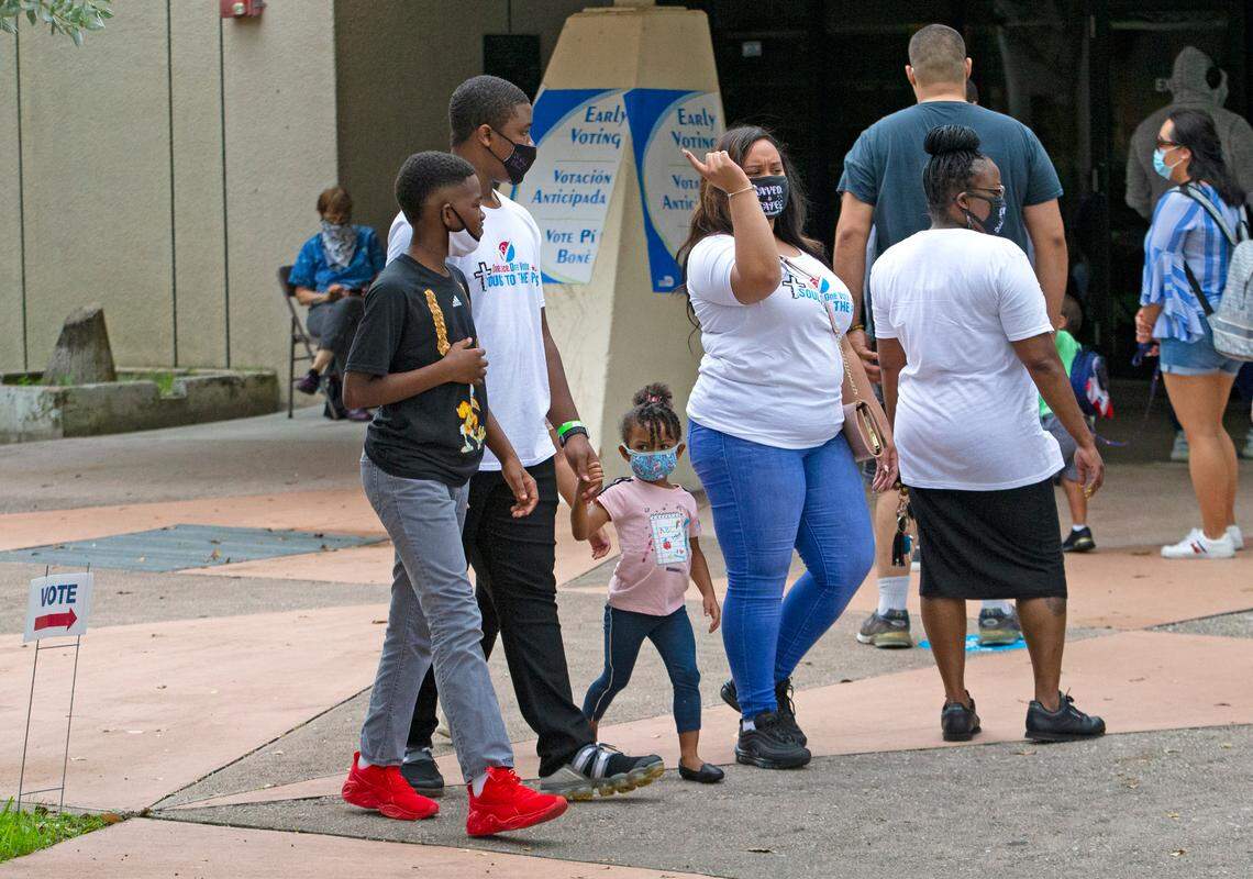 People walk outside the South Dade Regional Library during early voting for the general election at on Sunday, October 25, 2020, in Miami, Florida.