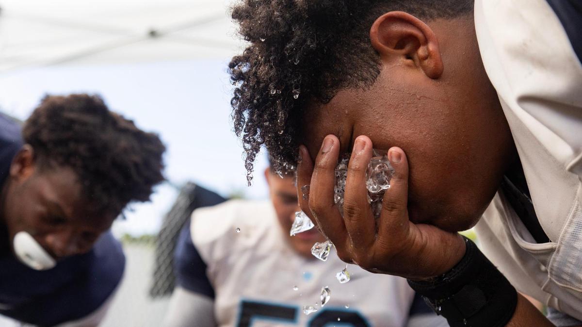 Daniel Fandino, offensive lineman, holds ice to his face to cool off during the Palmetto Panthers football practice on Monday, Aug. 7, 2023 in Pinecrest, Fla.