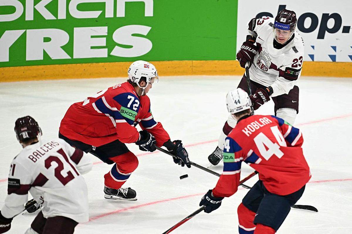 Latvia's forward #23 Sandis Vilmanis (top R) and Latvia's forward #21 Rudolfs Balcers (bottom L) vie for the puck with Norway's forward #44 Tinus Luc Koblar and Norway's defender #72 Stian Solberg during the IIHF Ice Hockey Men's World Championship quarter-final match between Norway and Latvia in Fribourg, Switzerland on May 28, 2026. (Photo by Fabrice COFFRINI / AFP via Getty Images)
