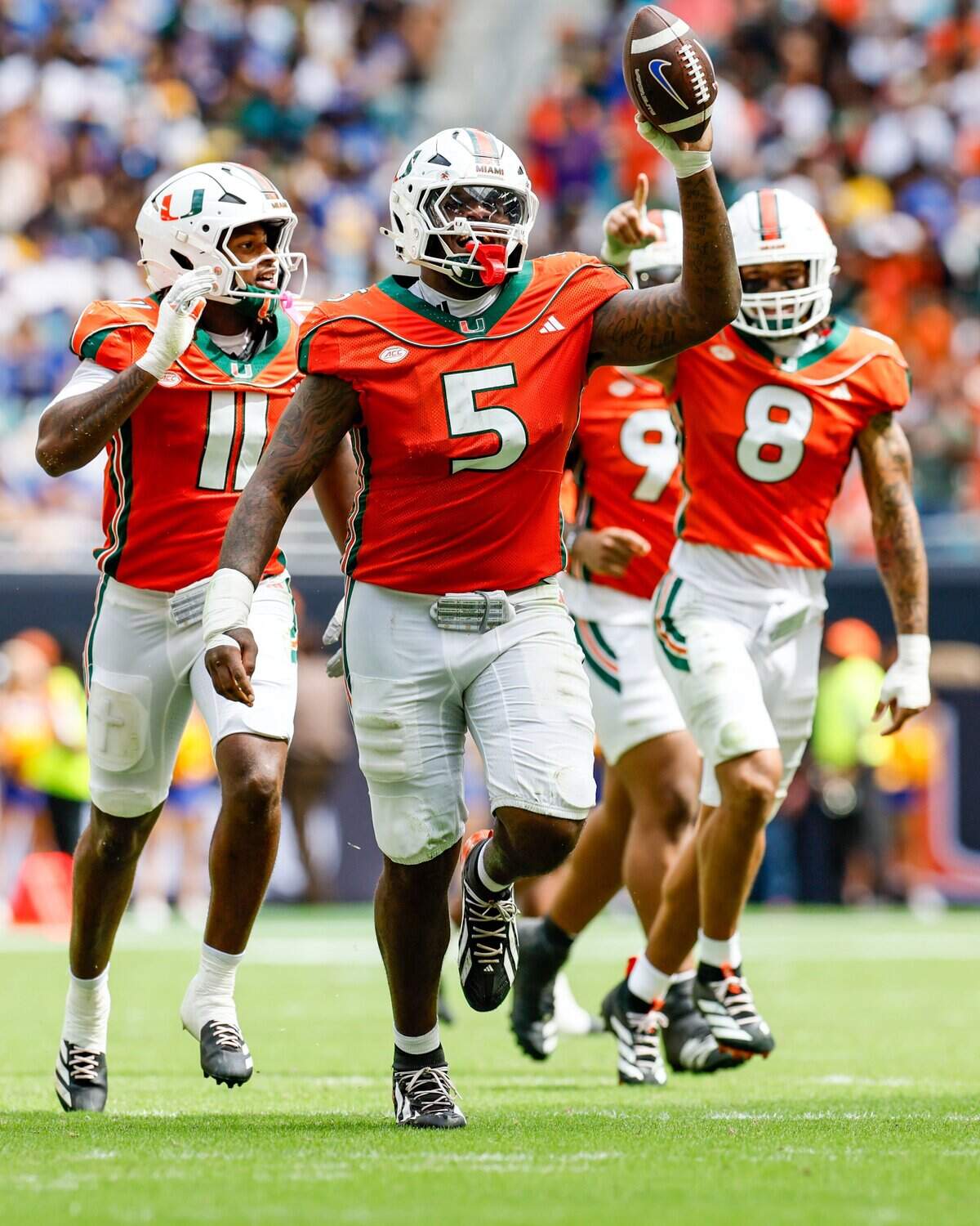 Miami Hurricanes defensive lineman Justin Scott (5) celebrates with teammates after recovering Pittsburgh Panthers fumble during the first half at Hard Rock Stadium in Miami Gardens, Florida, on Saturday, October 24, 2026.