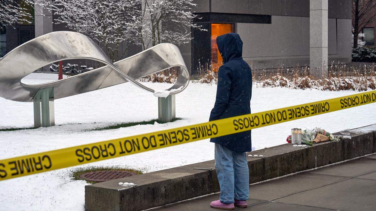 A person mourns at a makeshift memorial outside the Barus & Holley engineering building on the campus of Brown University, in Providence, Rhode Island on December 14, 2025. US authorities on Sunday detained a person of interest in the mass shooting at Brown University that left two people dead and nine others wounded, the latest in a long line of school attacks nationwide. (Photo by Bing Guan / AFP via Getty Images)