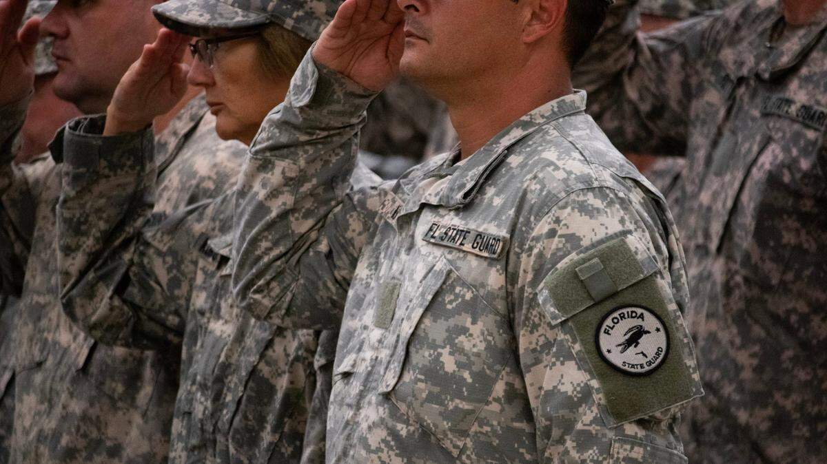 Miembros de la Guardia Estatal de la Florida oran durante la ceremonia de graduación en el Centro de Entrenamiento Conjunto Camp Blanding en Starke, Florida, el 30 de junio de 2023.