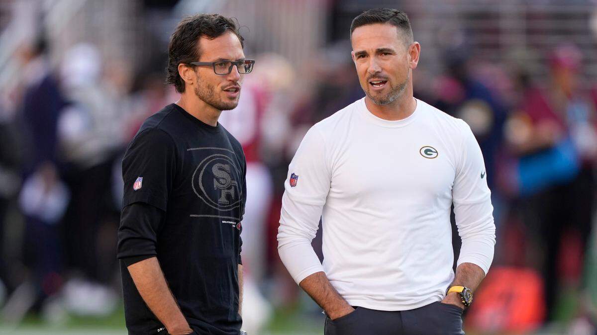 El coordinador ofensivo de los 49ers de San Francisco, Mike McDaniel, a la izquierda, habla con el entrenador en jefe de los Packers de Green Bay, Matt LaFleur, antes de un partido de la NFL en Santa Clara, California, el domingo 26 de septiembre de 2021.