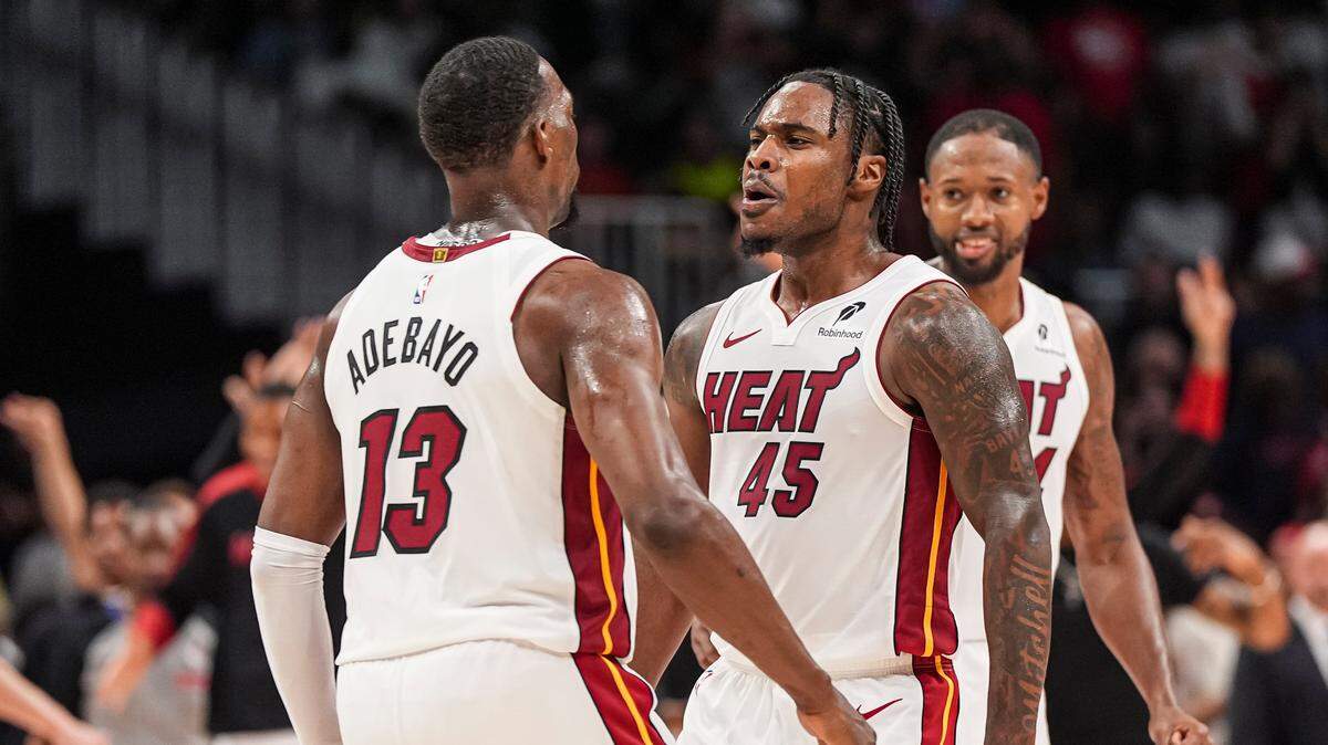 Miami Heat guard Davion Mitchell (45) reacts with center Bam Adebayo (13) after the Heat defeated the Atlanta Hawks in overtime at State Farm Arena.