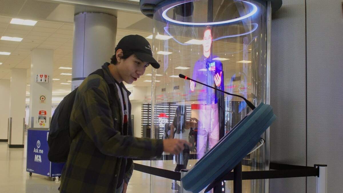 Jonathan Lopez stops to check out an AI hologram assistant in his trip from California, at Miami International Airport on July 1, 2026.