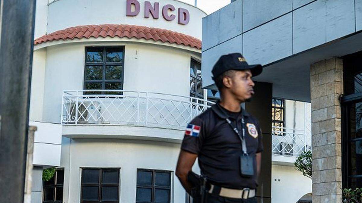 A Dominican police officer stands in front of the headquarters of the National Drug Control Directorate in Santo Domingo on February 12, 2026. The United States said on February 12, 2026, it was closing its Drug Enforcement Administration office in the Dominican Republic over unspecified corruption claims. (Photo by Danny Polaco / AFP via Getty Images)