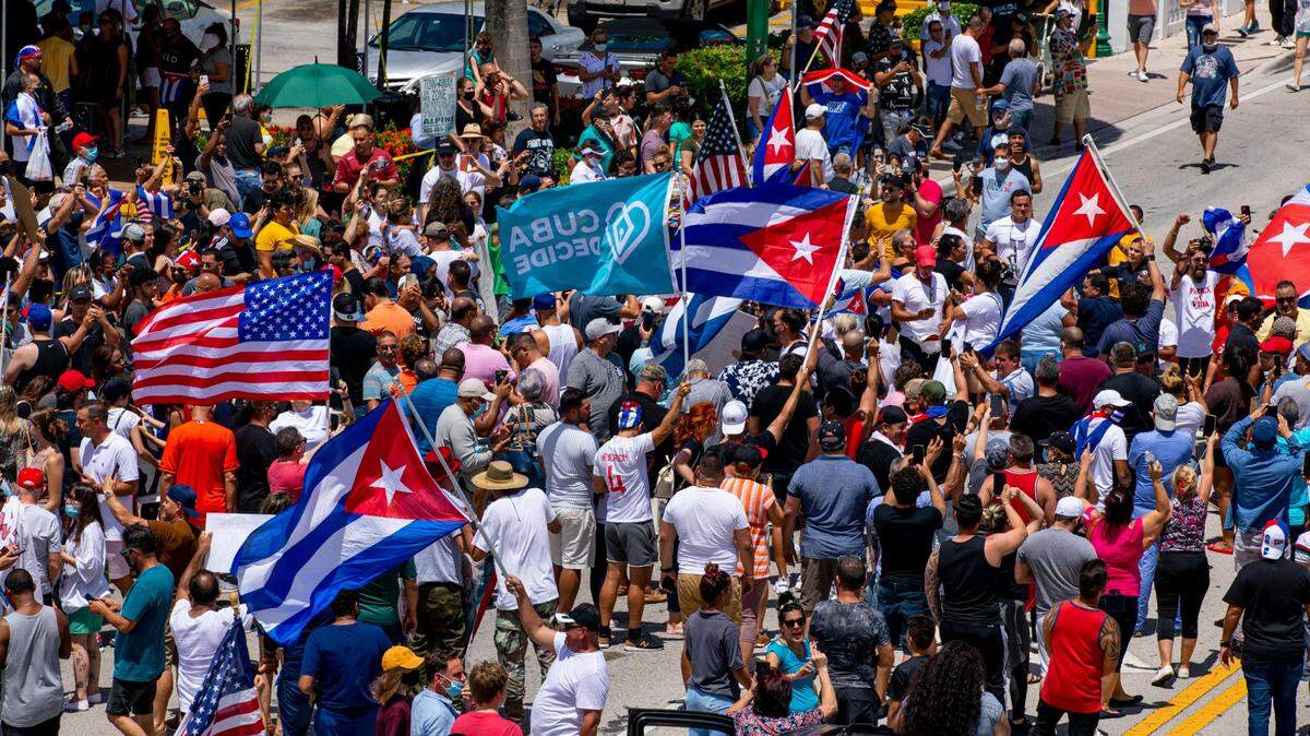 People march in the streets and wave Cuban flags during a protest in solidarity with thousands of Cubans who took to the streets this Sunday in various locations in Cuba, in one of the largest protests to take place on the island, at Versailles Cuban Restaurant off 8th Street in the Little Havana neighborhood of Miami, Florida, on Sunday, July 11, 2021.
