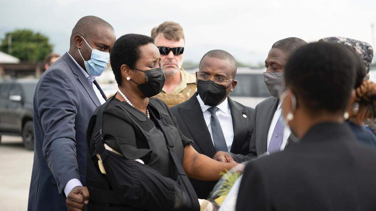 An emotional Martine Moïse, the first lady of Haiti, returns to the country from Miami on July 17, 2021, at the Toussaint Louverture International Airport in Port-au-Prince after being wounded in the July 7 attack that killed her husband, President Jovenel Moïse. She is greeted by Ardouin Zephirin, left, and acting Prime Minister Claude Joseph.
