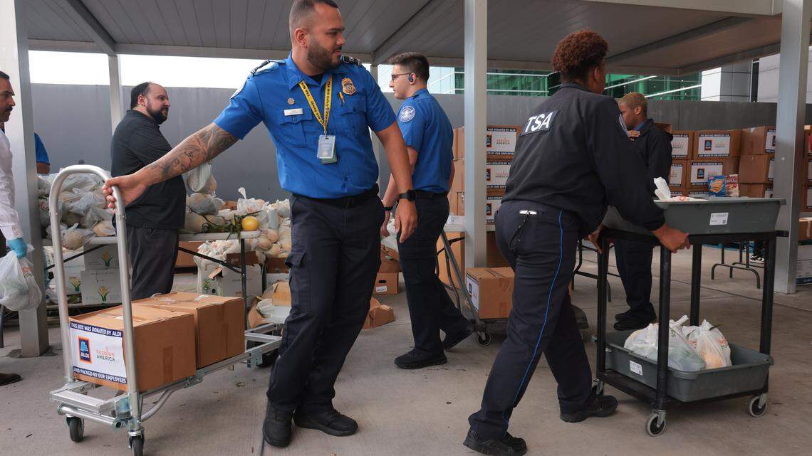 Transportation Security Administration workers impacted by the federal government shutdown collect food items inside a luggage cart at Miami International Airport in Miami, Florida, Friday, October 24, 2025.