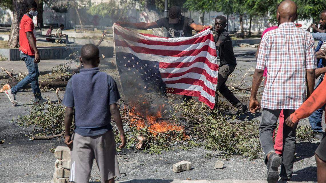 Protesters burn an American flag on February 7, 2021 in Port-au-Prince, Haiti to demand the resignation of president Jovenel Moïse, who seeks to extend his term of office until February 2022, which opposition groups say constitutionally ends this February 7.