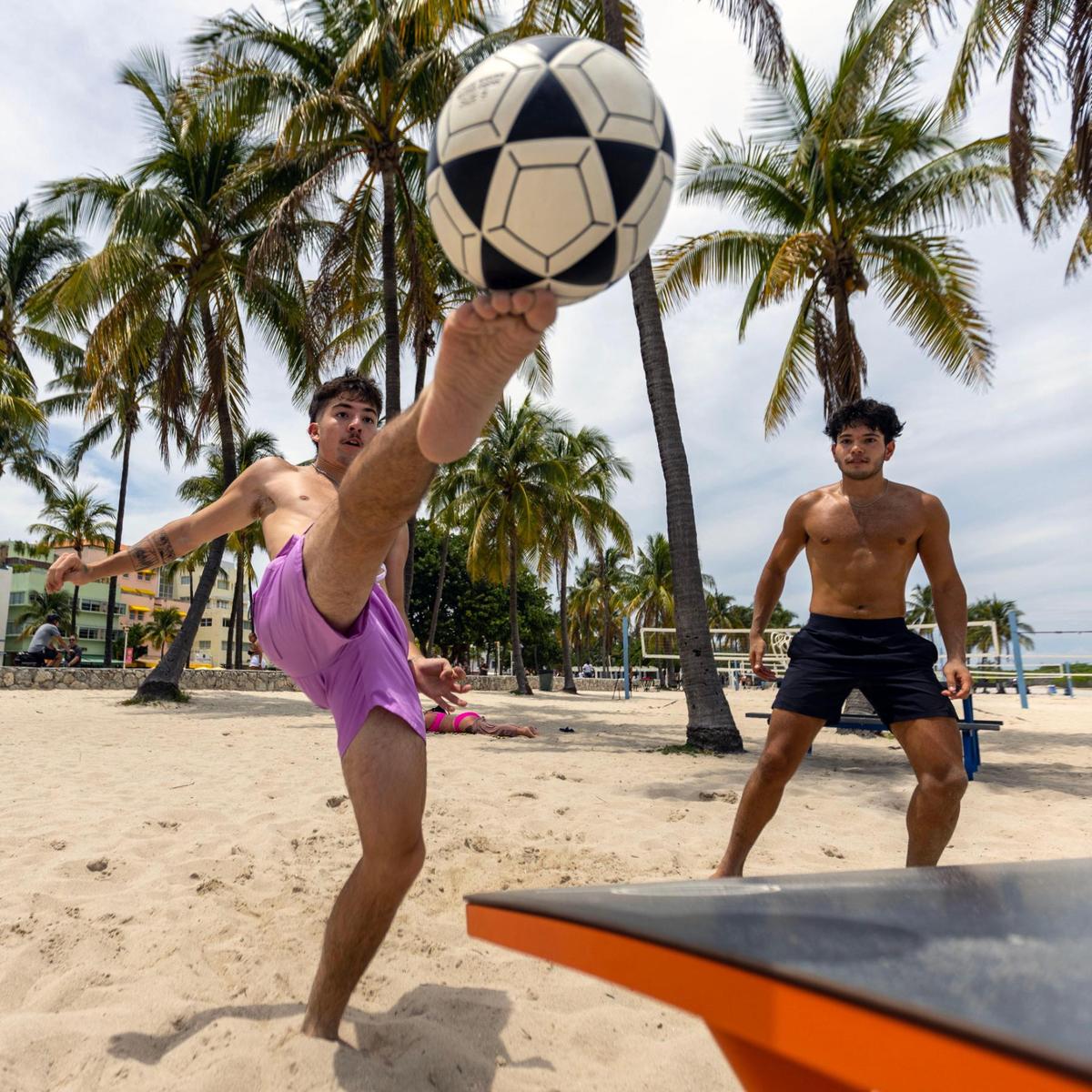 Miami locals Tobias Vales, left, and Diego Del Puerto, right, play Teqball near the beach walk during Memorial Day weekend at Miami Beach, Florida, on Monday, May 29, 2023. Teqball is similar to foosball in that it involves playing soccer on a table. It’s different in that you use your legs and head instead of your hands.