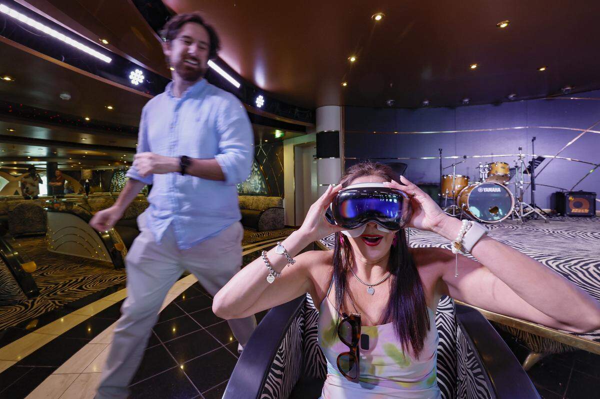 Zorita Molina watches a virtual reality experience of Alaska shore excursions while visiting the Zebra Bar on MSC Poesia at PortMiami in Miami, Florida, on Wednesday, April 22, 2026. Built in 2008, it underwent refurbishment this year. This winter, it will be based at PortMiami heading on trips to the Caribbean. Bar