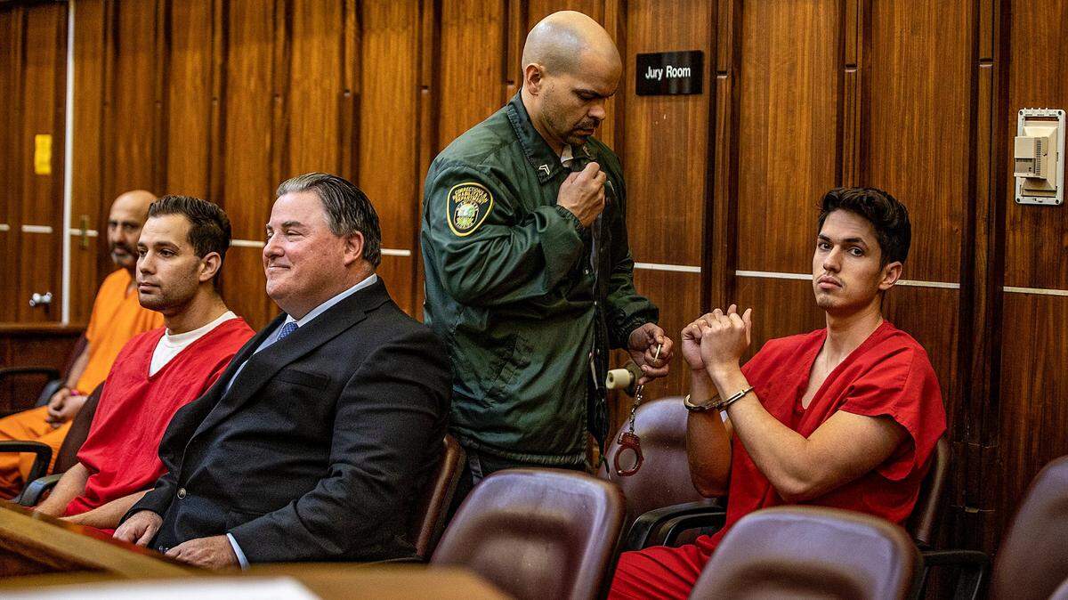 Defense attorney Michael Pizzi seats next to Hialeah Police officers Rafael Otano (left) and Lorenzo Orfila (far right), during the fifth day of their bail hearing in front of Judge Robert T. Watson.He is accused of kidnapping a homeless man, driving him to an isolated location, and beating him while he was handcuffed and leaving him behind unconscious. The hearing took place at the at the Richard E. Gerstein Justice Building, in Miami, on Friday February 10, 2023.