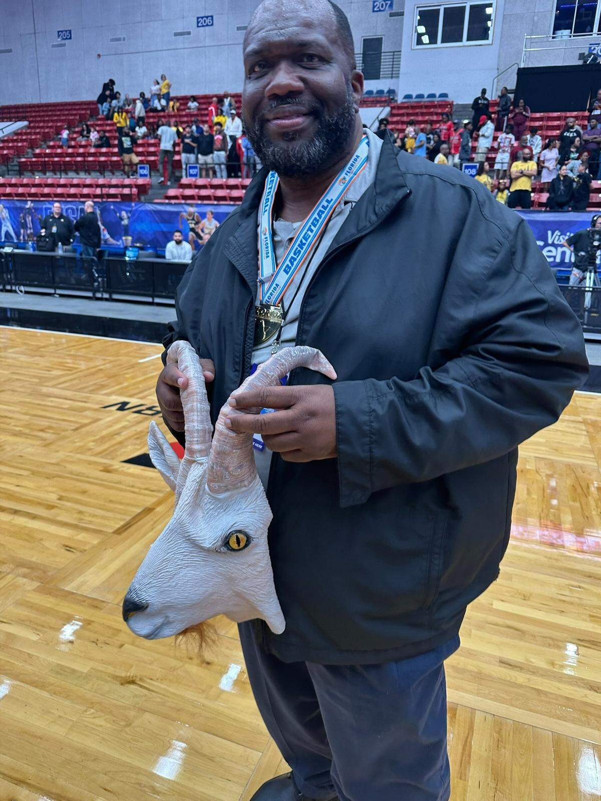 Norland coach Lawton Williams holds the goat mask his players brought him after winning his seventh state championship.