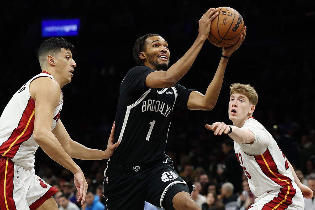 Ziaire Williams #1 of the Brooklyn Nets goes to the basket as Simone Fontecchio #0 and Kasparas Jakucionis #25 of the Miami Heat defend during the first half at Barclays Center on December 18, 2025 in the Brooklyn borough of New York City.
