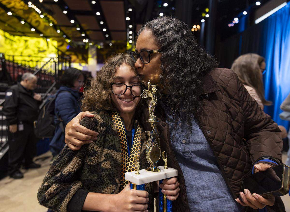 Maxine Williams kisses her son, Lancaster Gramer, 14, an eighth grader from Franklin Academy Cooper City, after he won the 86th Miami Herald Spelling Bee for Broward County at the Charles F. Dodge City Center on Wednesday, Feb. 25, 2026, in Pembroke Pines, Fla. Gramer won the competition after correctly spelling the winning word, californium.
