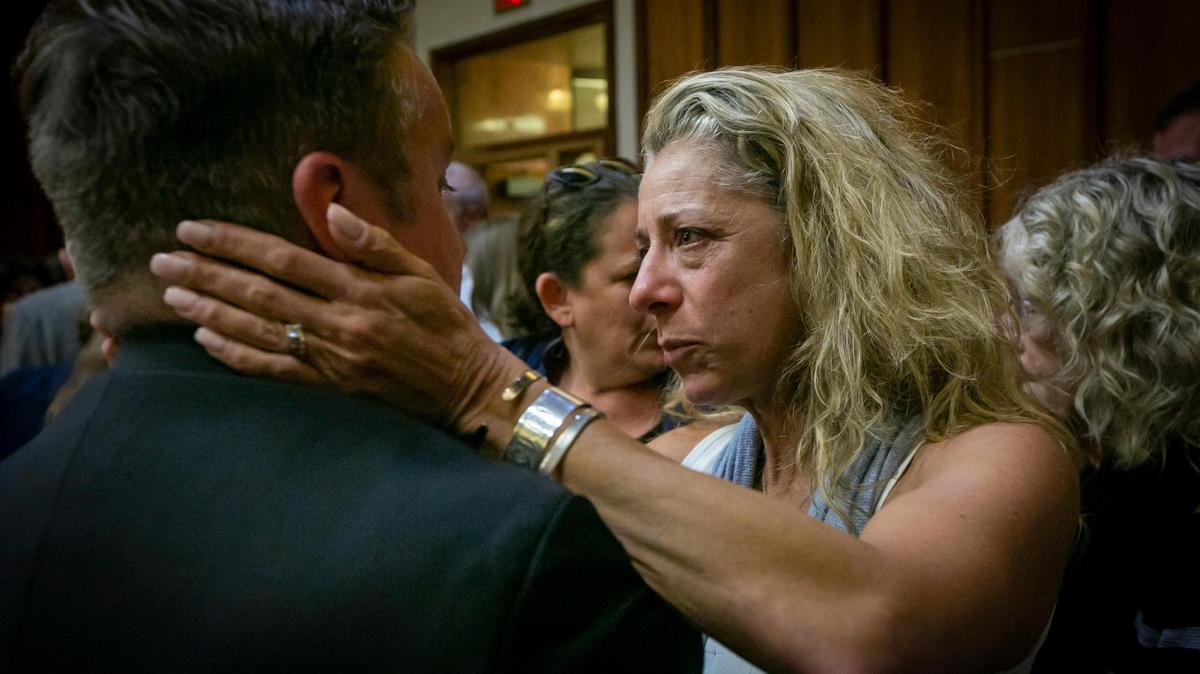 Daisy Holcombe, right, the widow of murder victim Camilo Salazar, hugs prosecuting attorney Justin Funck after the guilty verdict for Manuel Marin. Marin, a former Presidente Supermarket executive, was found guilty in a murder-for-hire plot that killed Salazar in 2011.