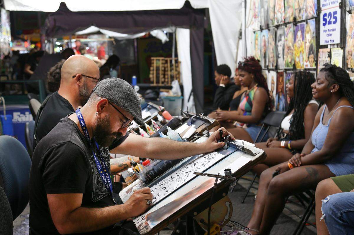 Cartoonist draw pictures during the opening day of the Miami-Dade County Youth Fair at the Miami-Dade Fair & Expo Center in Miami, Florida, on Thursday, March 17, 2022.