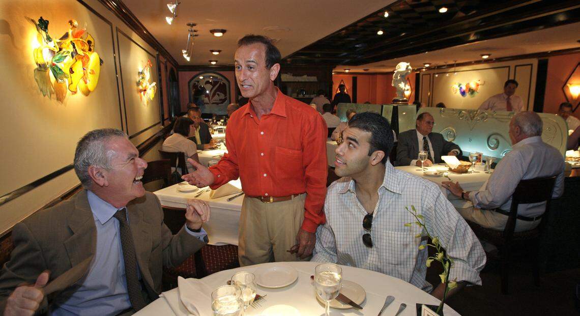 Nino Pernetti, owner of Caffe Abbracci, center, greets patrons Sylvester Lukis, left, and Paul Corrales.