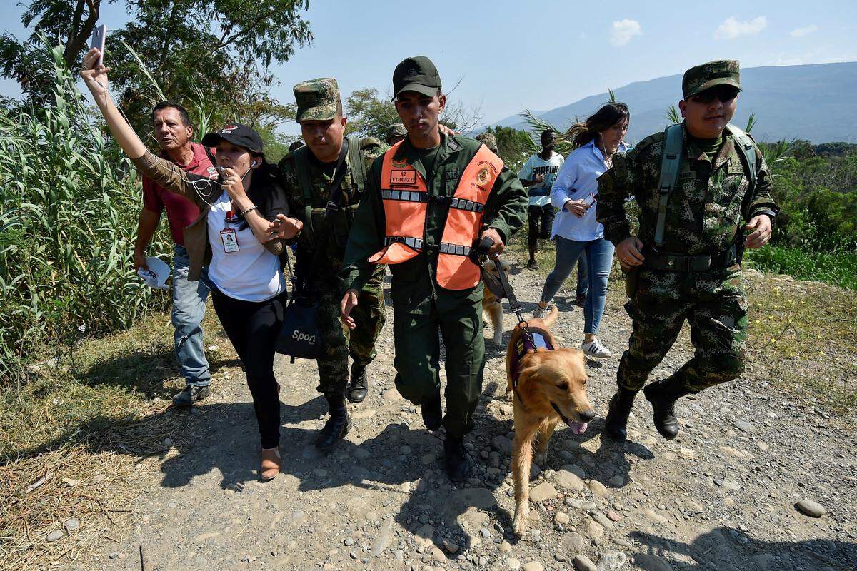 Colombian soldiers escort a member of the Bolivarian National Armed Forces of Venezuela who deserted to Colombia with his dog, in Cúcuta on February 25, 2019.