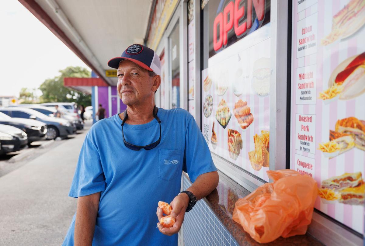 Pablo pela una mandarina afuera del supermercado Sabor Tropical el jueves 3 de octubre de 2024 en Miami. Su alquiler ha subido $500 este año y dice que recibe cupones para poder comprar alimentos.