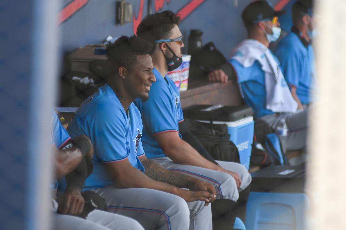 Miami Marlins pitcher Sixto Sanchez smiles in the dugout in the first inning of a spring training game against the Houston Astros on Monday, March 15, 2021, at the Ballpark of the Palm Beaches in West Palm Beach, Florida.