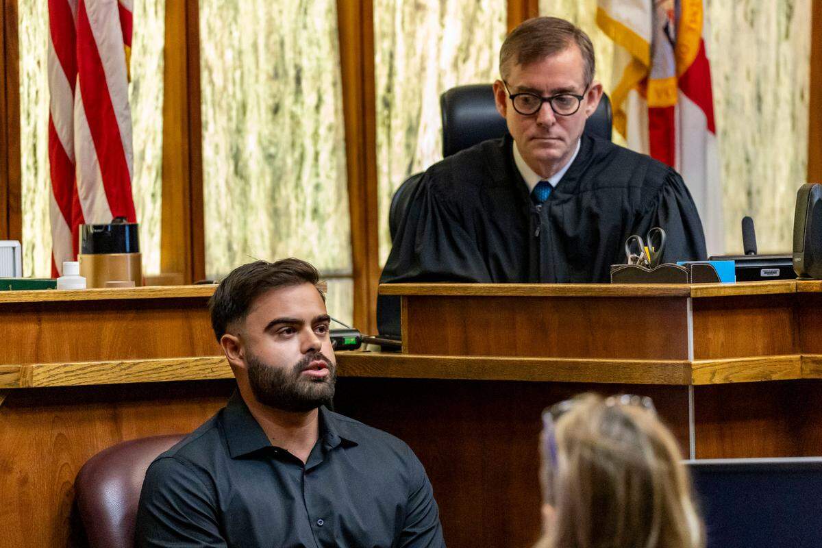 Miami, Florida, Oct. 22, 2024 - With Judge Miguel de la O looking on, Sergio Berben, left, the then-boyfriend of Andrea Camps-Lacayo, testifies on the first day of Adrian Cosby’s trial. Cosby is accused of shooting to death Camps-Lacayo in 2020 in a botched robbery.