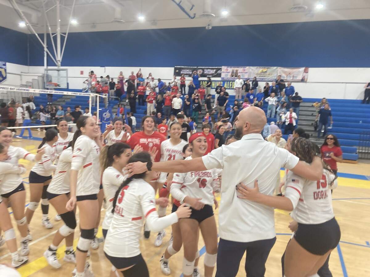 Doral Academy girls’ volleyball team celebrates on the court at Cypress Bay High in Weston, Fla. after defeating the Lightning in the Region 4-7A final.