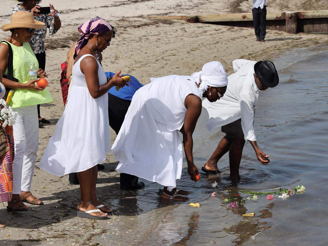Attendees place offerings in remembrance of ancestors from Africa who perished while traveling through the Middle Passage during the slave trade in a 2019 commemoration event hosted by the NAACP at Historic Virginia Key Beach.