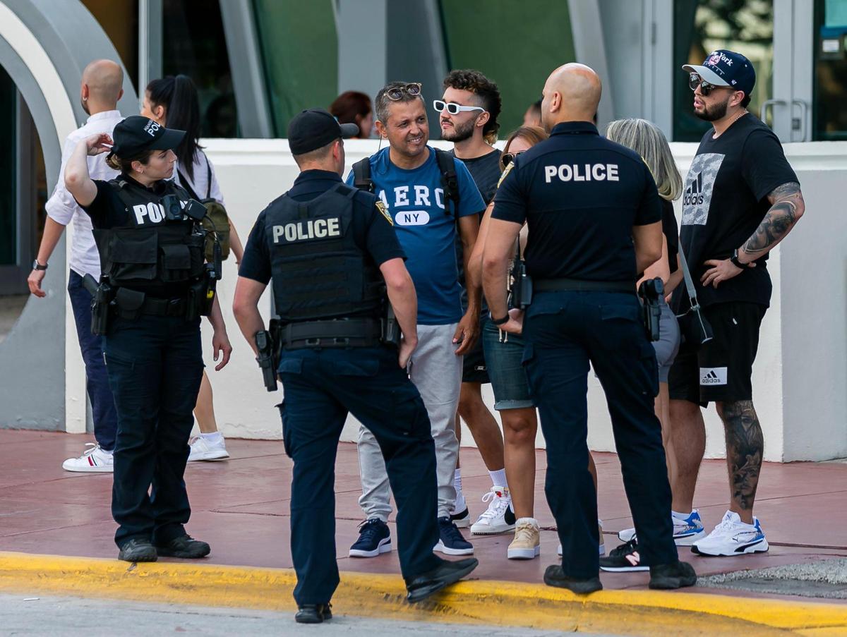 Police interact with others on Ocean Drive in Miami Beach on Friday, Feb. 25, 2022.