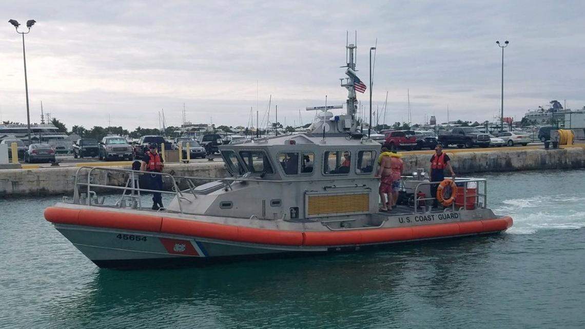 Three men who were rescued by the U.S. Coast Guard off Sugarloaf Key stand on the deck of a Medium Endurance Response boat Wednesday, Jan. 9, 2018.