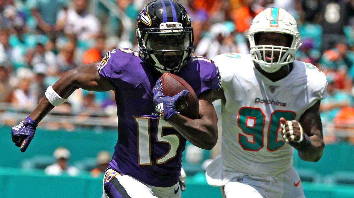 Miami Dolphins defensive end Charles Harris (90) chases Baltimore Ravens Marquise Brown (15) as he runs for a first quarter touchdown at Hard Rock Stadium in Miami Gardens, Florida, Sunday, September, 8, 2019.