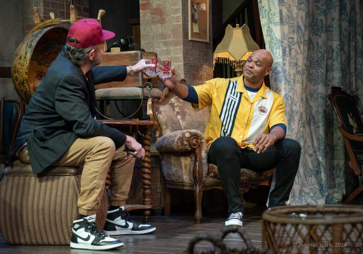 At left, Matt (Gregg Weiner) and Shawn (Melvin Huffnagle) raise a glass to Matt’s new business in “King James” at GableStage through Nov. 24.