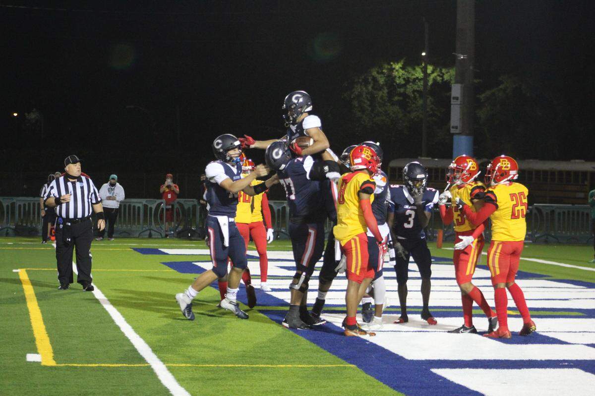 Columbus players hoist receiver Chris Gibert into the air following his 3-yard touchdown reception in the first quarter that gave the Explorers an early lead over Deerfield Beach.